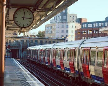 A city train station with a train on the tracks during sunrise. Ideal for urban and transportation themes.